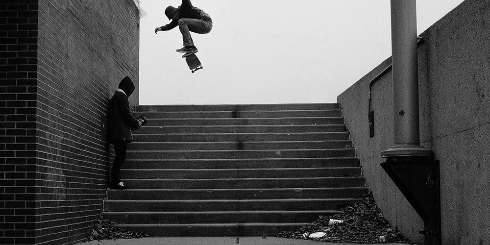 Skateboarder doing trick over steps